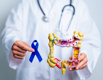 Lekarz trzyma model jelita grubego oraz niebieską wstążkę symbolizującą profilaktykę raka jelita grubego.